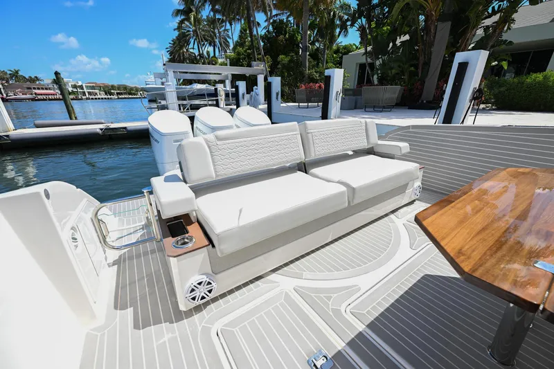 Slide: The Image of 2023 Tiara Yachts 48 LS luxury yacht deck with seating and table, docked by the water. - 46