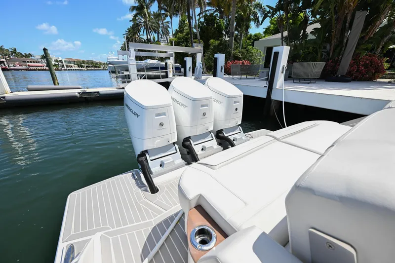 Slide: The Image of 2023 Tiara Yachts 48 LS with triple outboard engines docked by a waterfront. - 47