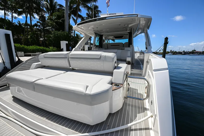 Slide: The Image of 2023 Tiara Yachts 48 LS luxury yacht with spacious seating, docked by palm trees. - 49
