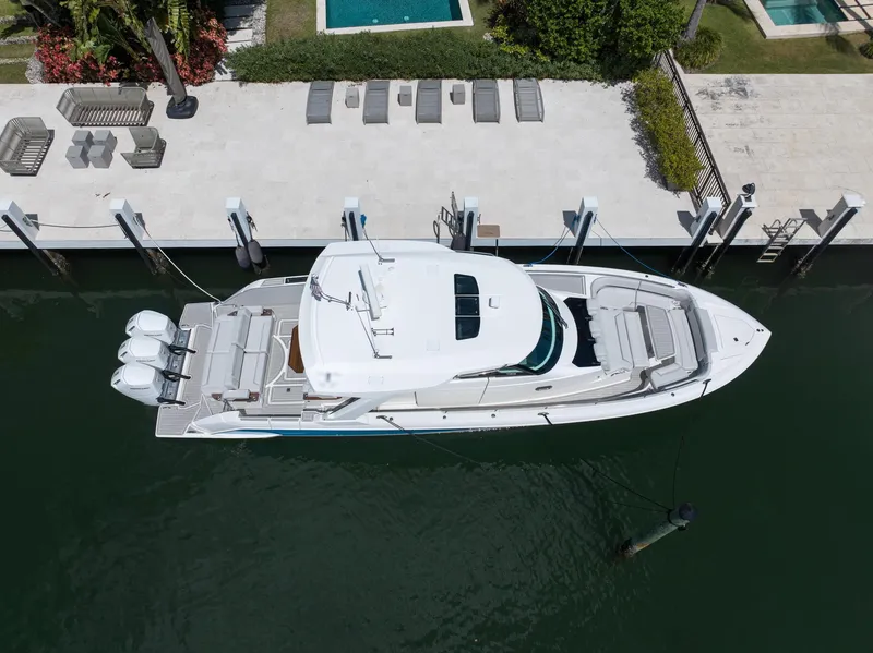 Slide: The Image of 2023 Tiara Yachts 48 LS docked, aerial view showcasing sleek design and triple engines. - 5