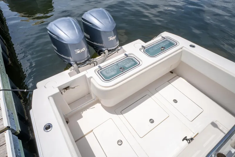 Slide: The Image of 2014 Contender 30st boat with dual outboard engines, docked on calm water. - 15