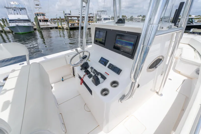 Slide: The Image of 2014 Contender 30st boat console with dual screens and steering wheel at marina. - 20