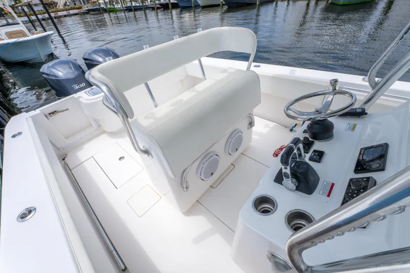 Slide: The Image of 2014 Contender 30st boat cockpit with helm, seating, and dual engines at dock. - 21