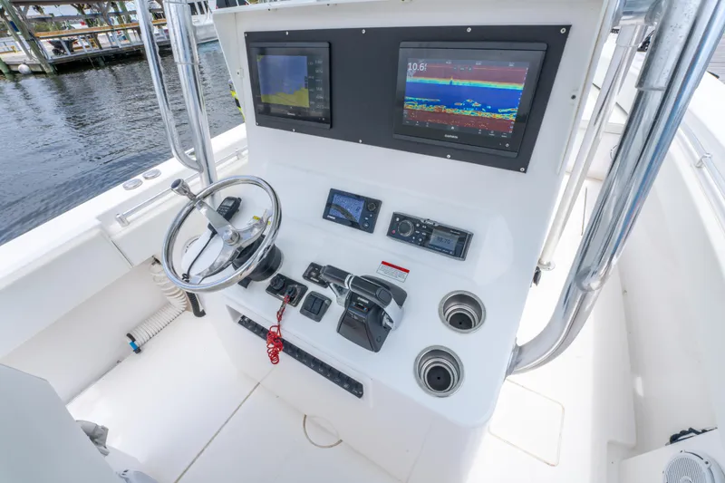 Slide: The Image of Control panel of a 2014 Contender 30st boat with navigation screens and steering wheel. - 22