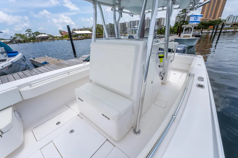 Slide: The Image of 2014 Contender 30st boat interior, featuring white seating and sleek design at a marina. - 25
