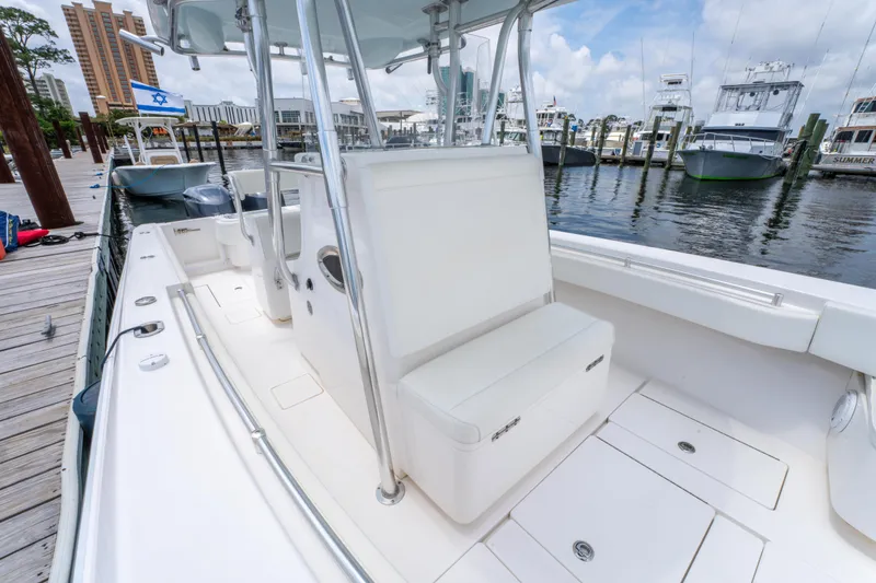 Slide: The Image of 2014 Contender 30st boat interior at marina, featuring seating and storage compartments. - 26