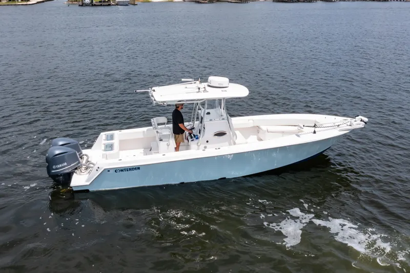 Slide: The Image of 2014 Contender 30st boat on water, featuring dual outboard engines and a center console. - 6