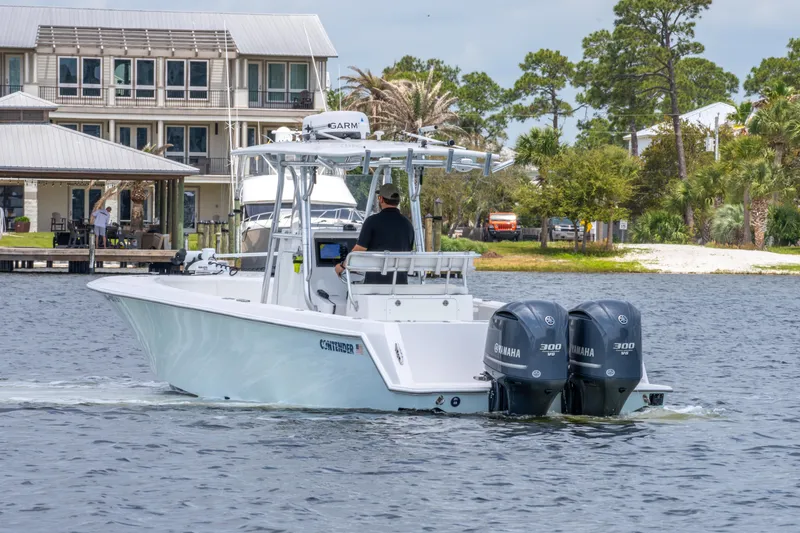 Slide: The Image of 2014 Contender 30st boat with dual Yamaha engines cruising near waterfront homes. - 7