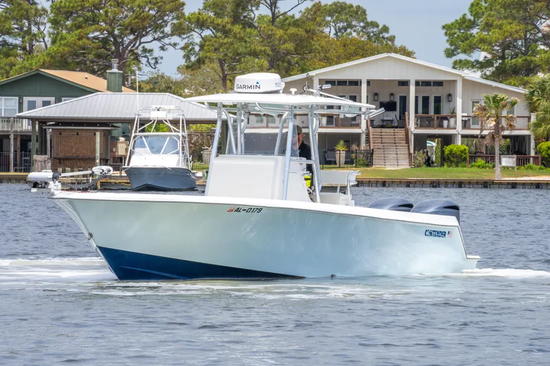 Slide: The Image of 2014 Contender 30st boat cruising on a lake near waterfront homes. - 8