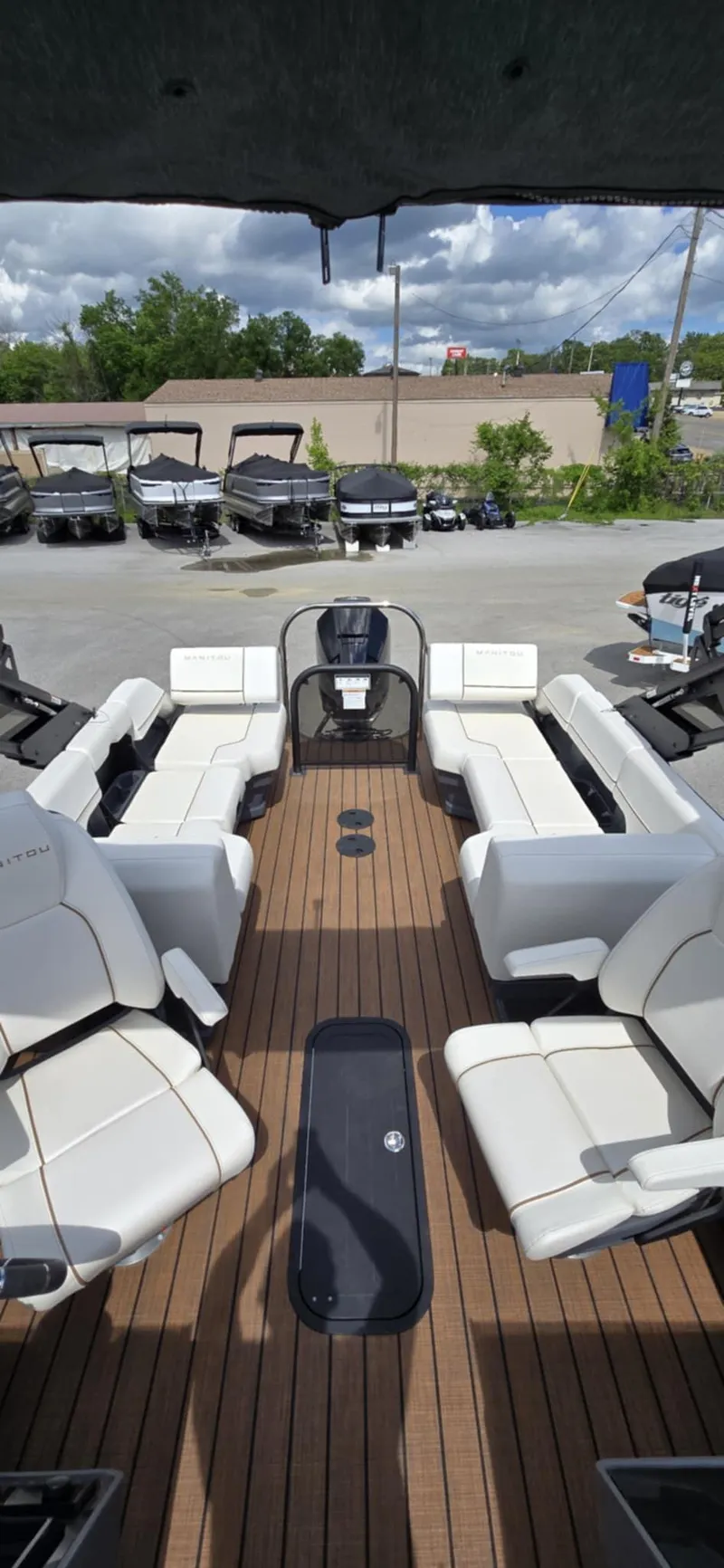 Slide: The Image of 2025 Manitou Explore boat interior with white seating and wooden flooring. - 16