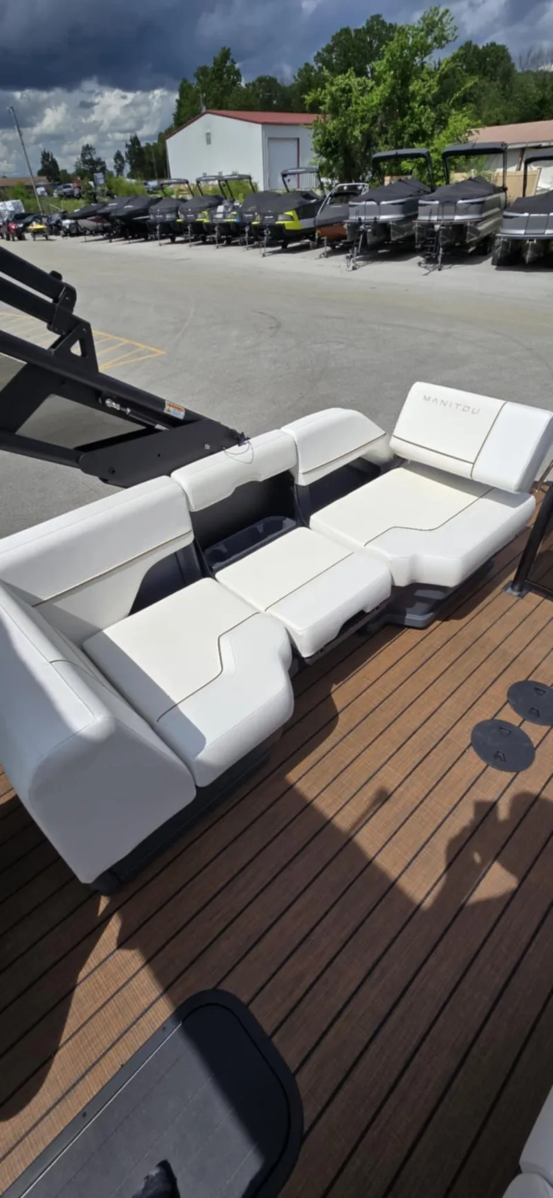 Slide: The Image of 2025 Manitou Explore boat seating on wooden deck under cloudy sky. - 17