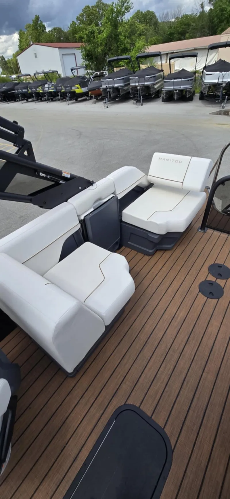 Slide: The Image of 2025 Manitou Explore boat with white seating and wooden deck. - 20