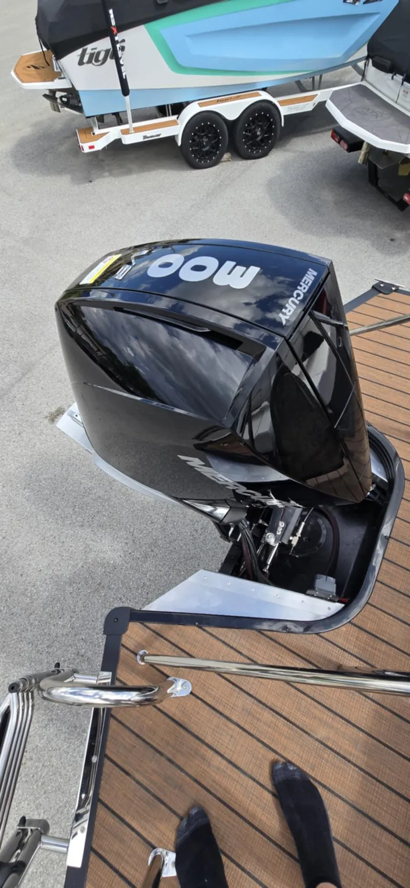 Slide: The Image of 2025 Manitou Explore boat engine on a wooden deck, showcasing sleek design and power. - 21