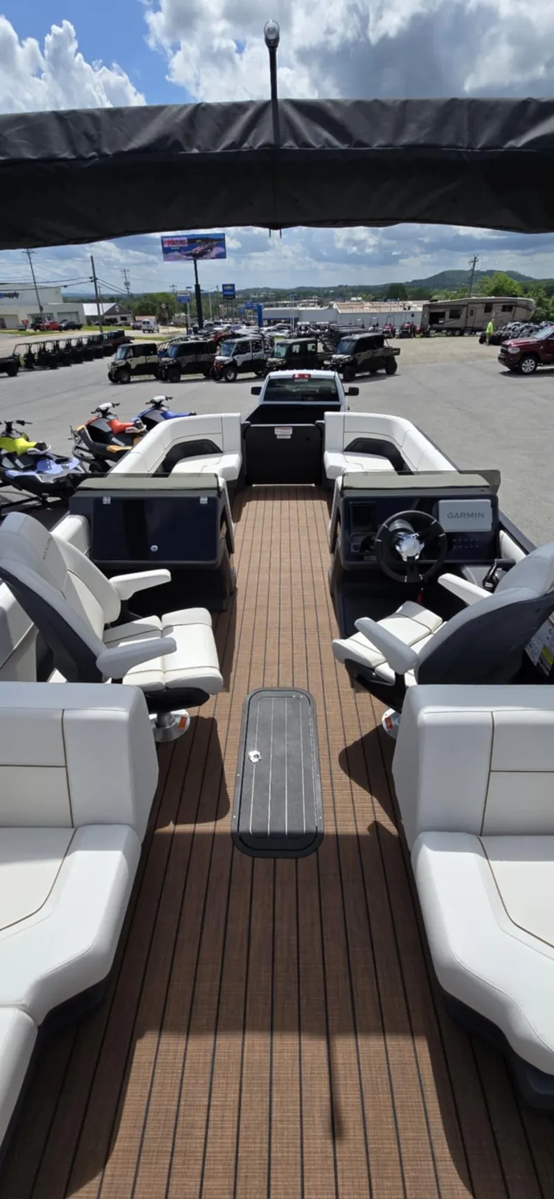 Slide: The Image of 2025 Manitou Explore boat with spacious seating and modern design, displayed outdoors under a cloudy sky. - 24