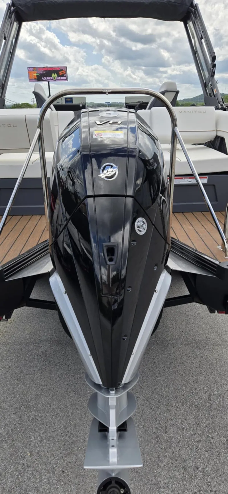 Slide: The Image of 2025 Manitou Explore boat with sleek black design and modern features, docked outdoors. - 7
