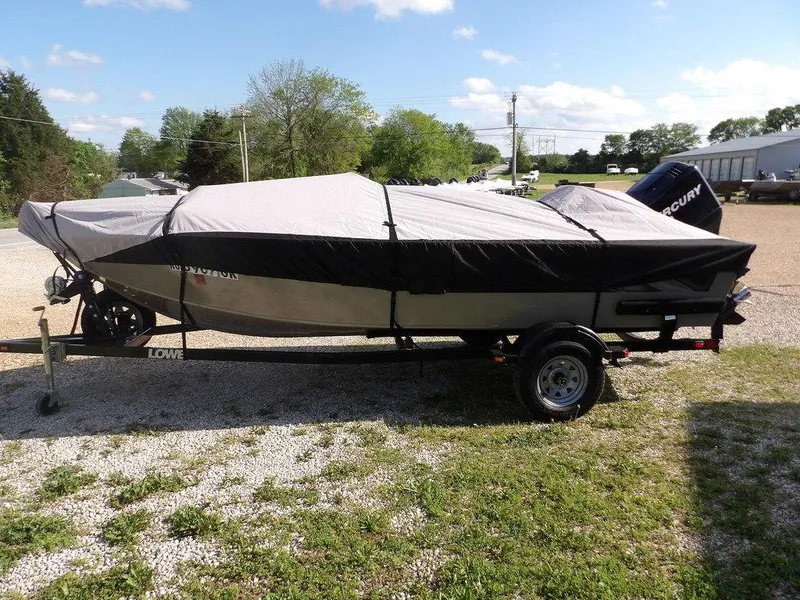 Slide: The Image of Covered 2006 Lowe FM165SC boat on trailer, parked outdoors on gravel. - 1