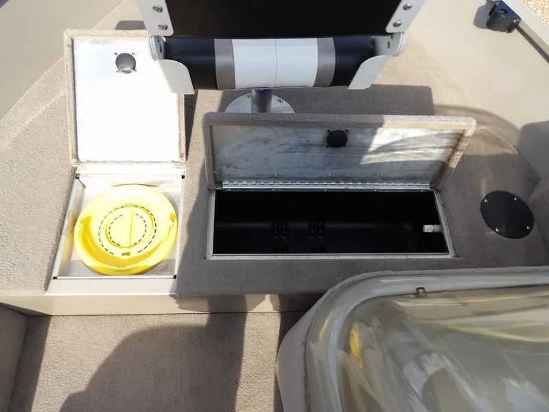 Slide: The Image of 2006 Lowe FM165SC boat interior with open storage compartments and seating. - 15