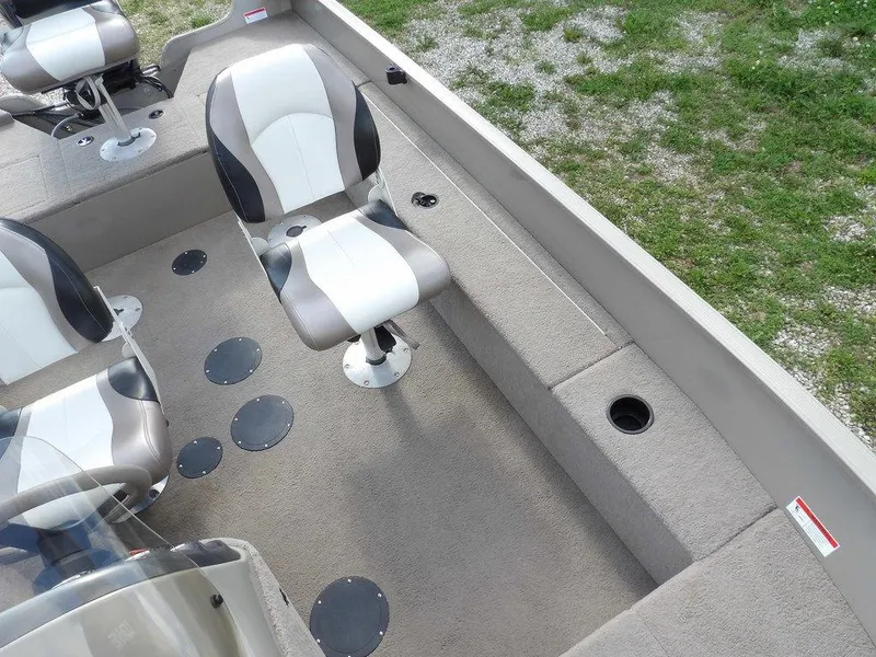 Slide: The Image of 2006 Lowe FM165SC boat interior with swivel seats and carpeted flooring. - 16