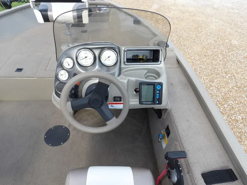 Slide: The Image of 2006 Lowe FM165SC boat dashboard with steering wheel, gauges, and navigation system. - 18
