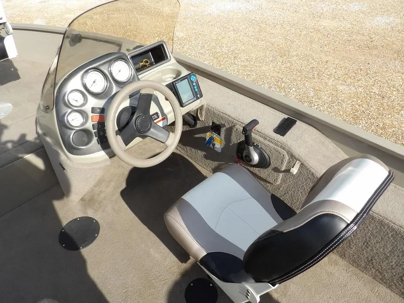 Slide: The Image of 2006 Lowe FM165SC boat cockpit with steering wheel, gauges, and cushioned seat. - 21