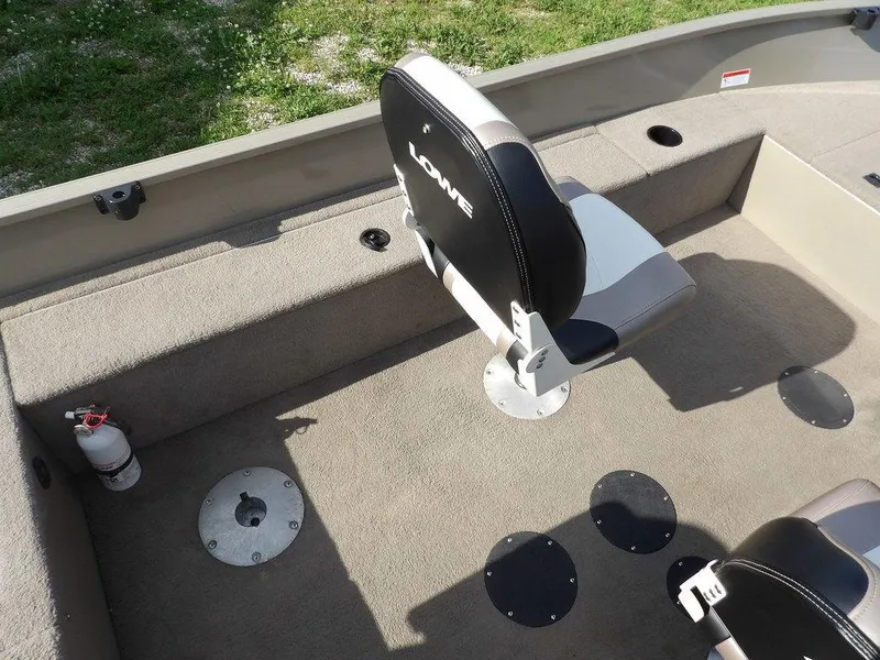 Slide: The Image of 2006 Lowe FM165SC boat interior with seating and fire extinguisher on carpeted deck. - 23