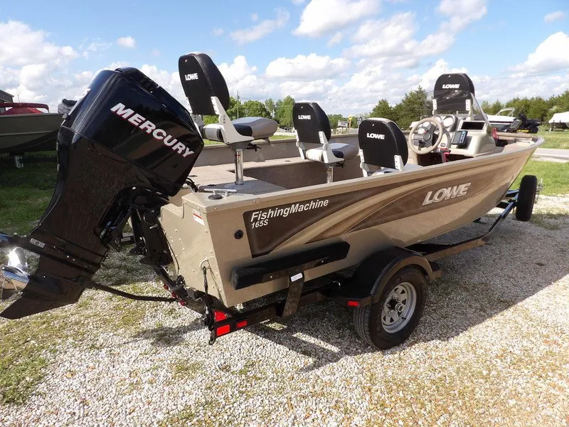 Slide: The Image of 2006 Lowe FM165SC fishing boat with Mercury engine on a trailer, parked outdoors. - 30