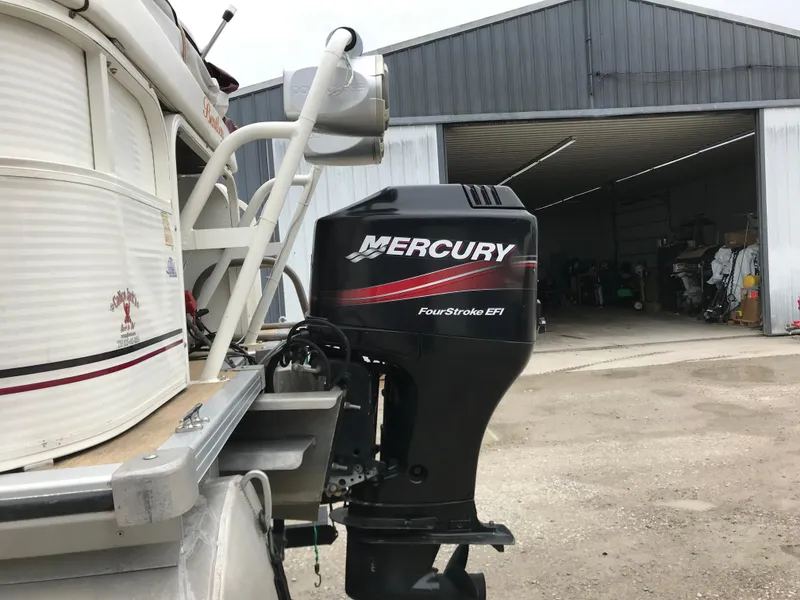 Slide: The Image of 2005 Bentley Pontoons 243 with Mercury FourStroke EFI outboard motor near a garage. - 12