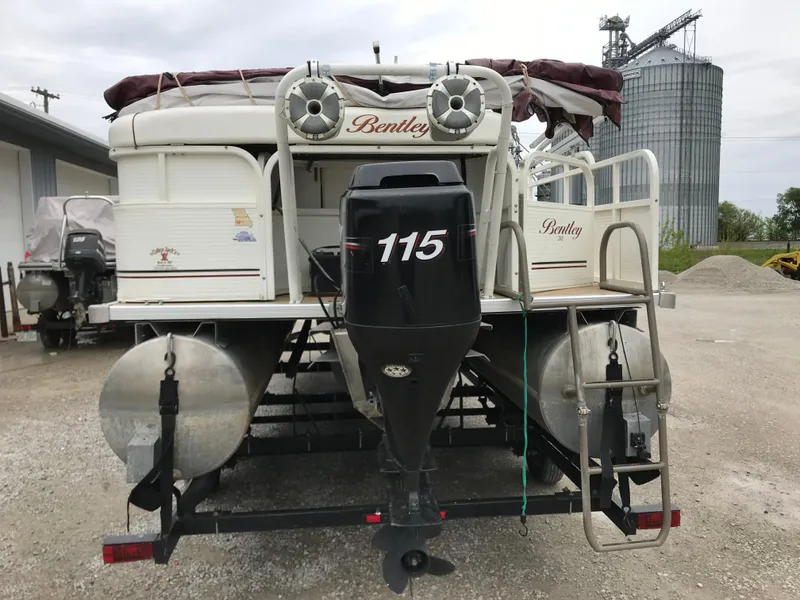 Slide: The Image of 2005 Bentley Pontoons 243 with 115 HP motor, parked on gravel near industrial silos. - 13