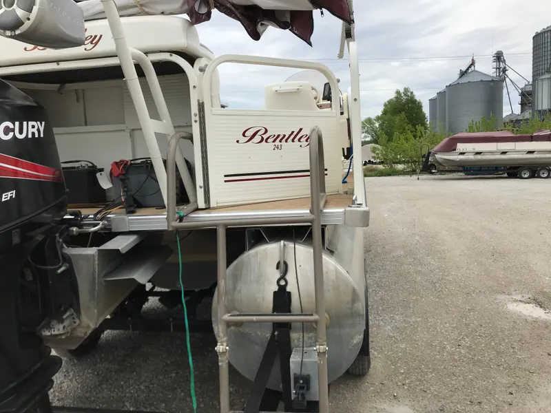 Slide: The Image of 2005 Bentley Pontoons 243 boat with Mercury engine, parked near industrial area. - 14