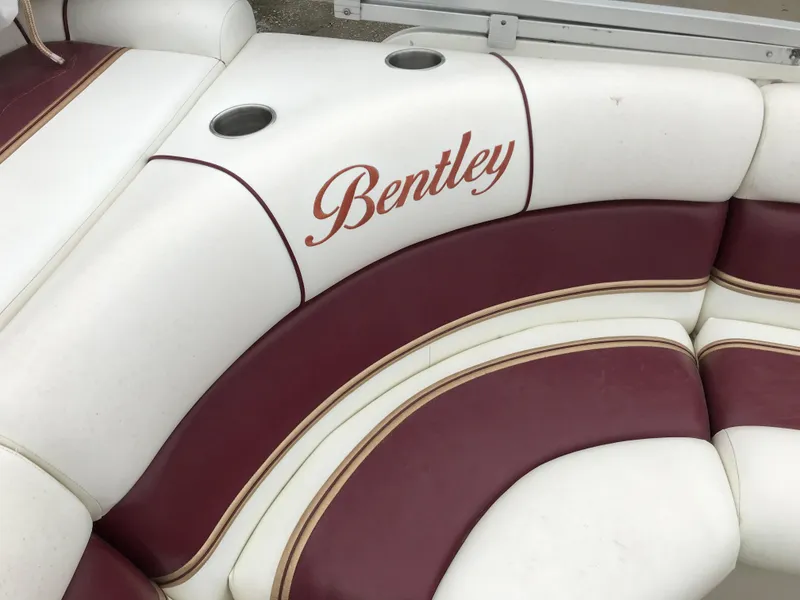 Slide: The Image of 2005 Bentley Pontoons 243 interior with white and maroon seating, featuring cup holders. - 16
