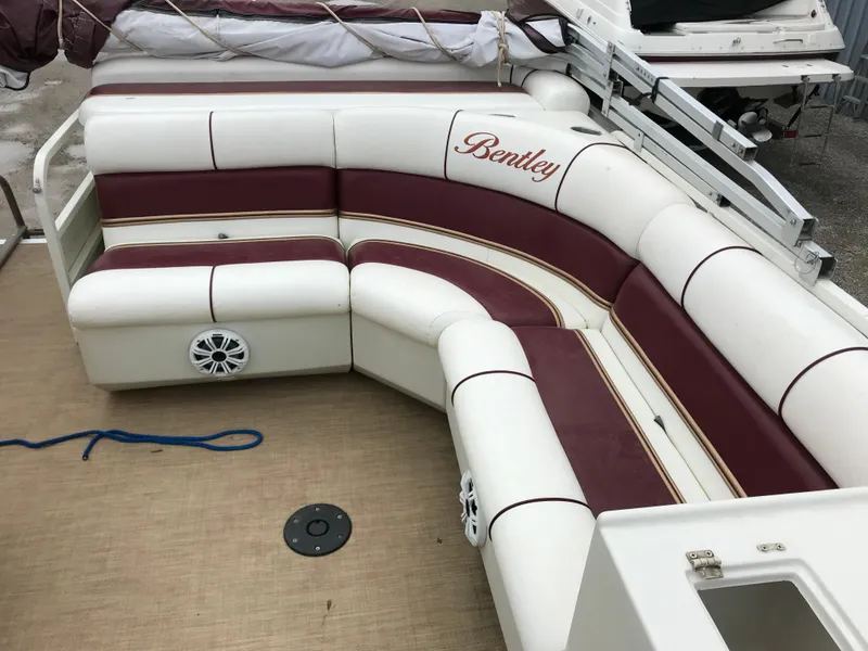 Slide: The Image of 2005 Bentley Pontoons 243 interior with maroon and white seating, featuring a curved design. - 19