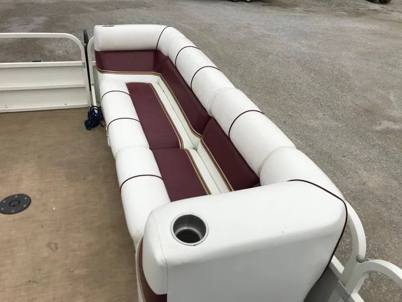 Slide: The Image of 2005 Bentley Pontoons 243 interior with white and maroon seating, cup holder, and spacious layout. - 23
