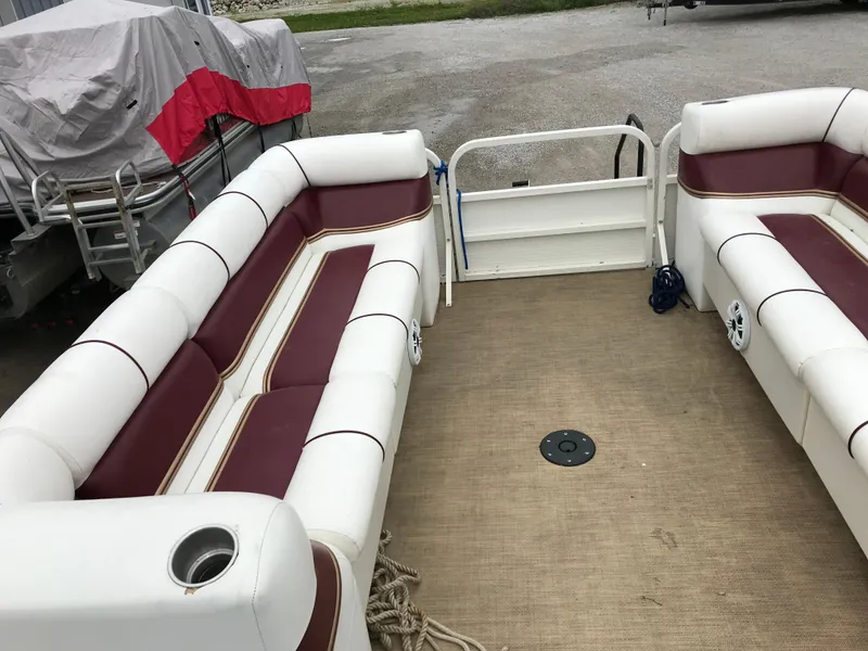 Slide: The Image of 2005 Bentley Pontoons 243 interior with white and maroon seating, spacious deck layout. - 24