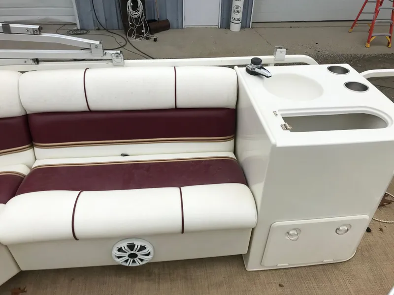 Slide: The Image of 2005 Bentley Pontoons 243 interior with maroon and white seating and built-in cup holders. - 7