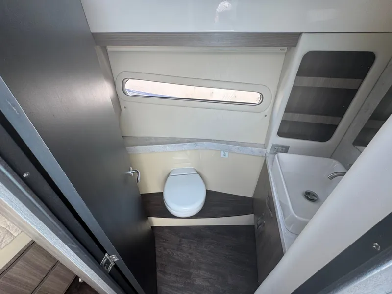 Slide: The Image of The bathroom of a Regal 38 XO yacht with a toilet and sink. - 13