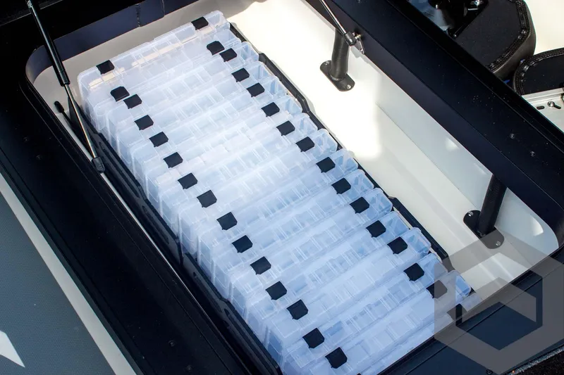 Slide: The Image of Storage compartment with organized tackle boxes in a 2025 Skeeter FXR 21 Limited boat. - 25