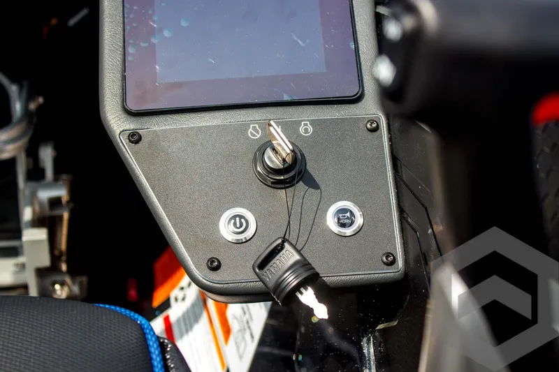 Slide: The Image of Control panel of 2025 Skeeter FXR 21 Limited boat with ignition key and power button. - 36