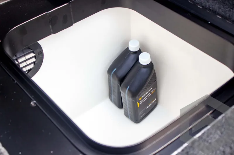 Slide: The Image of Storage compartment in 2025 Skeeter FXR 21 Limited with two oil containers. - 44