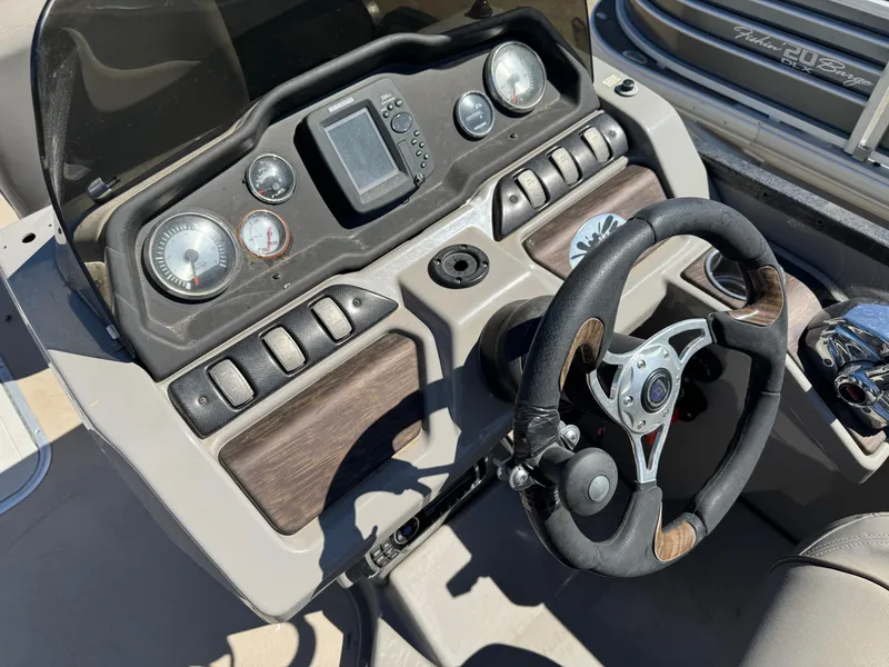 Slide: The Image of 2014 Premier 251 Cast-A-Way boat dashboard with steering wheel and gauges. - 14