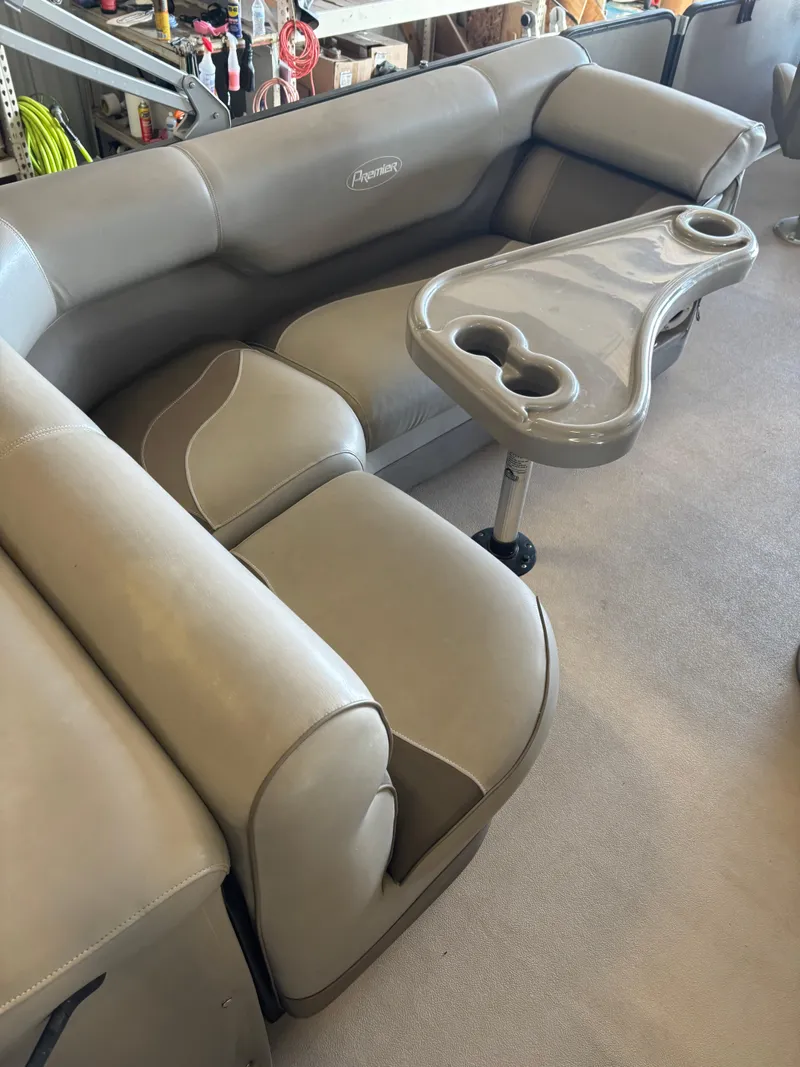 Slide: The Image of 2014 Premier 251 Cast-A-Way boat interior with beige seating and cupholder table. - 22