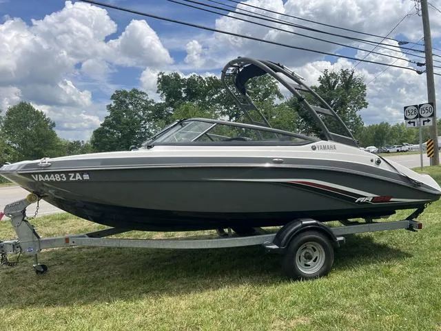 Slide: The Image of 2019 Yamaha AR195 boat on trailer, parked on grass under a cloudy sky. - 17