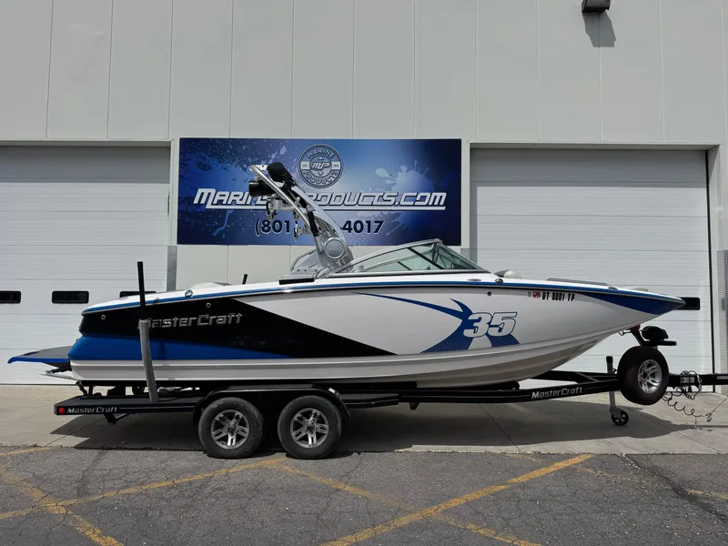 Slide: The Image of 2013 MasterCraft X35 boat on trailer, parked outside dealership. - 0