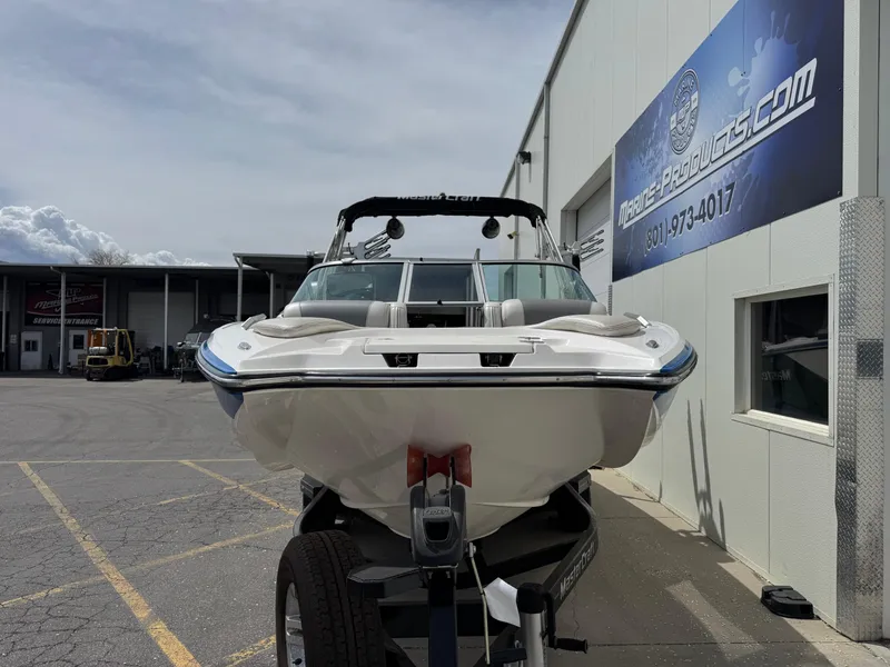 Slide: The Image of 2013 MasterCraft X35 boat on trailer outside marine products store. - 2