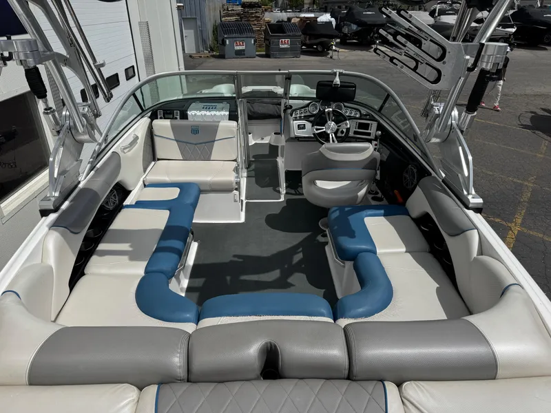 Slide: The Image of 2013 MasterCraft X35 boat interior with blue and gray seating, spacious layout, and modern dashboard. - 7
