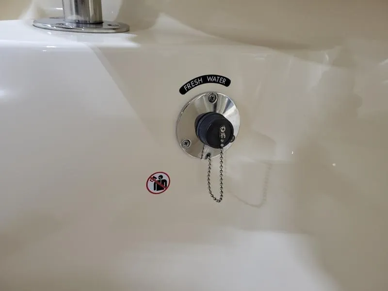 Slide: The Image of Fresh water inlet on 2019 Grady-White 336 Canyon boat, with safety warning label. - 13