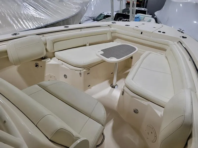 Slide: The Image of 2019 Grady-White 336 Canyon boat interior with cream seating and table. - 17