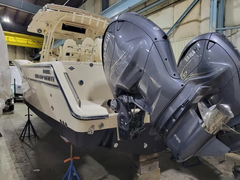 Slide: The Image of 2019 Grady-White 336 Canyon boat with dual Yamaha engines in a storage facility. - 36