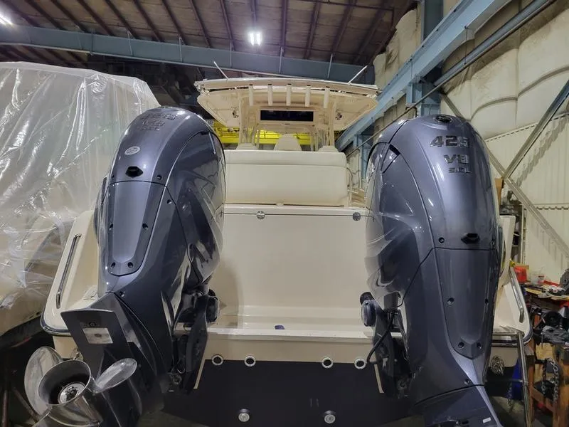 Slide: The Image of 2019 Grady-White 336 Canyon boat with dual 425 HP outboard engines in a warehouse. - 37