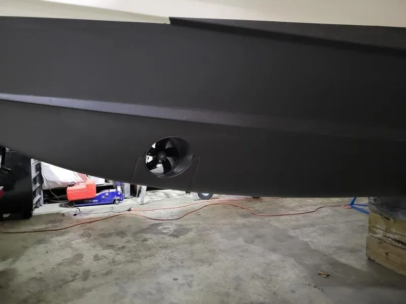 Slide: The Image of 2019 Grady-White 336 Canyon boat hull with visible thruster in a garage setting. - 42