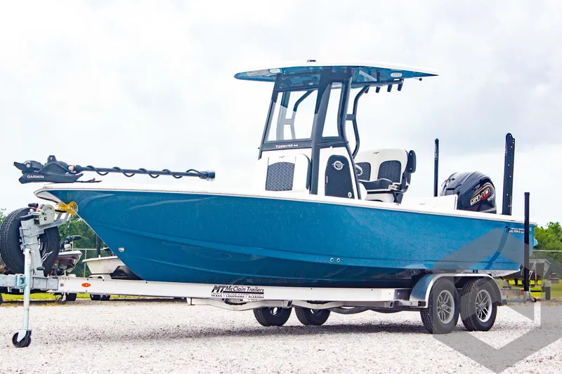 Slide: The Image of 2025 Tidewater 2410 Bay Max boat on trailer, blue hull, center console, outboard motor. - 1